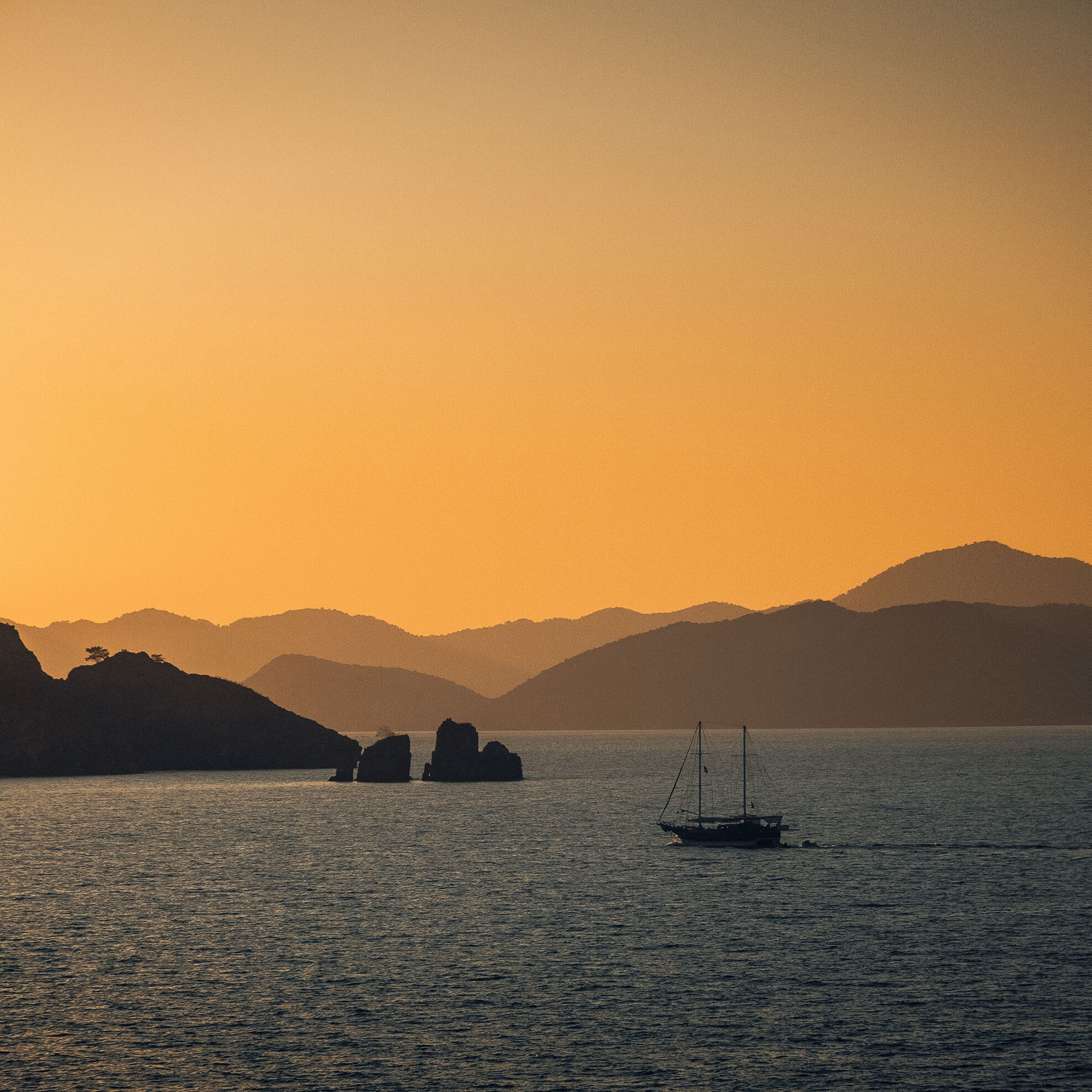 Boat passing mountains in distance sunrise small