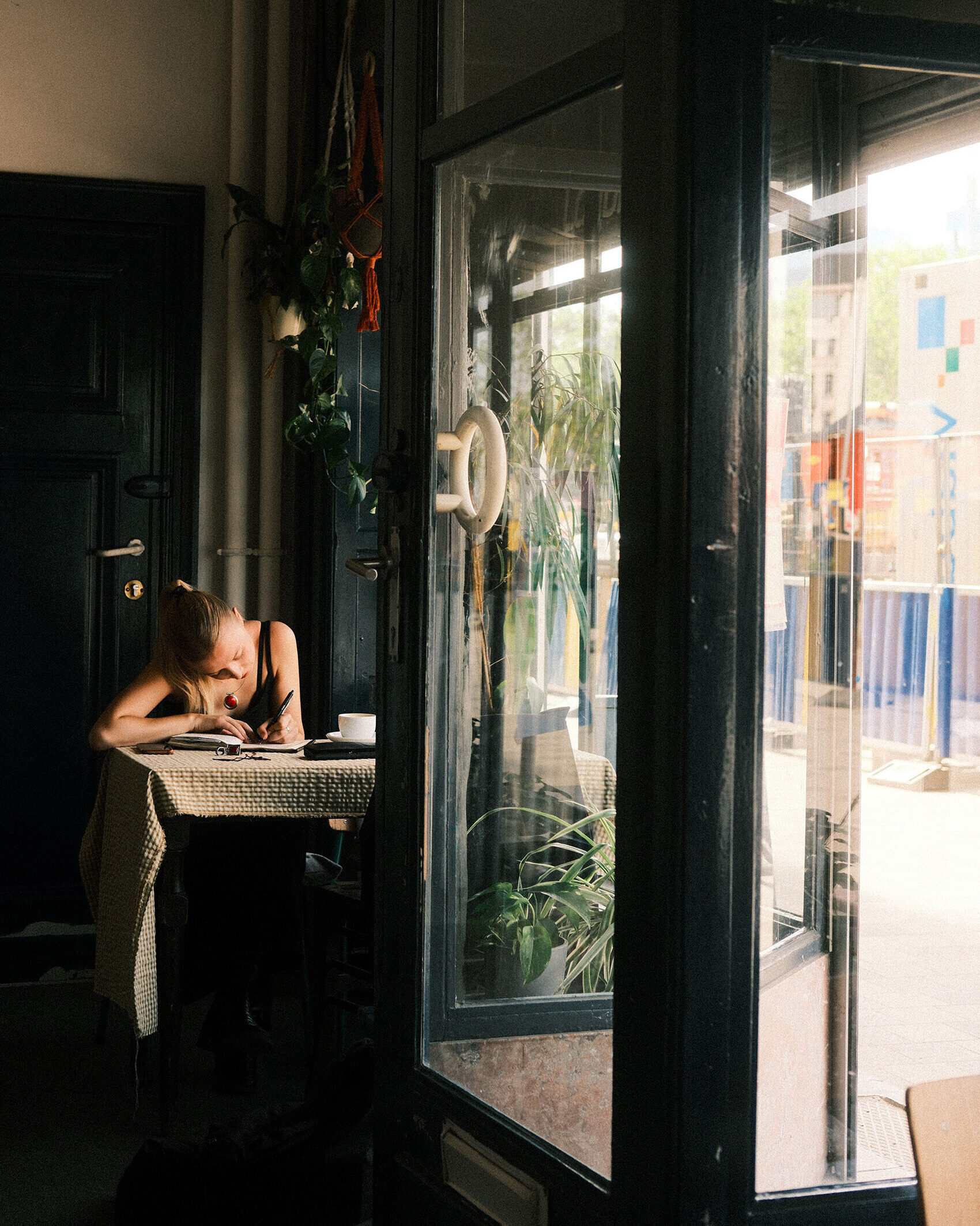 Woman making notes in cafe sunlight small
