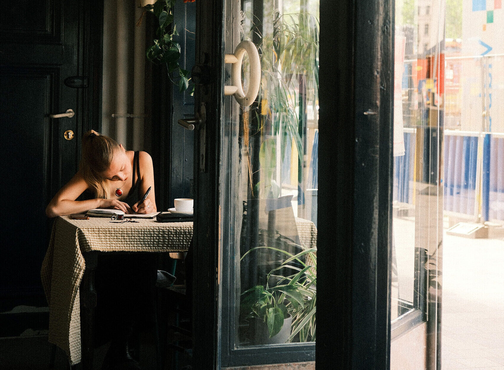 Woman making notes in cafe sunlight small